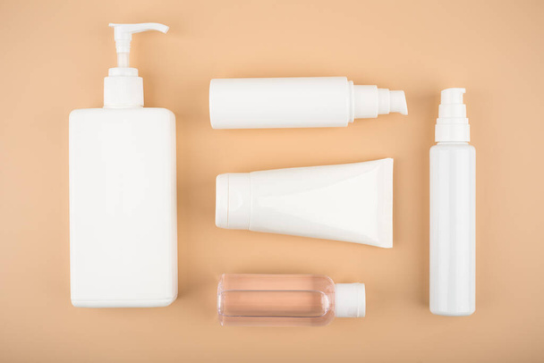 Flat lay with a set of cosmetic products for daily skin and body care routine on beige background - Foto, imagen