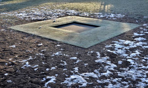 trampolína zapuštěné podzemí je měkký gumový koberec hrát na hřišti, kde skoky na hrací ploše z gumových dlaždic kolem je trávník a běhouny z betonových desek - Fotografie, Obrázek