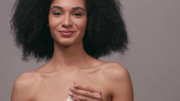 pozitív afro-amerikai nő alkalmazó dezodor izolált szürke - Felvétel, videó