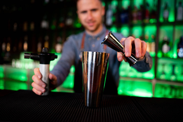 Молодий хлопець працює барменом, готуючи коктейлі в пабі
 - Фото, зображення
