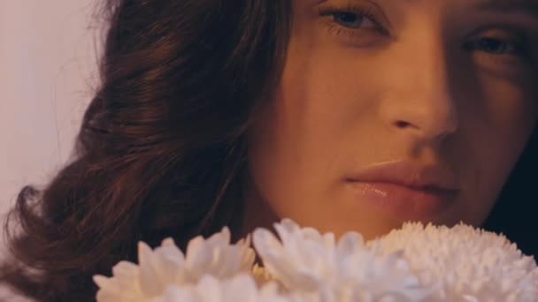 крупним планом кучерява молода жінка біля букета білих квітів на білому
 - Кадри, відео
