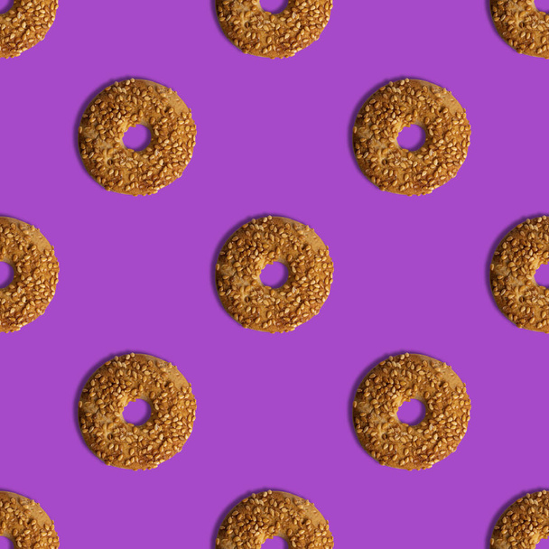 Szablon cookies z nasionami sezamu na fioletowym tle. Widok z góry. Kreatywny design, minimalna płaska koncepcja układania. - Zdjęcie, obraz