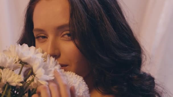 sensual woman smelling bouquet of flowers on white - Πλάνα, βίντεο