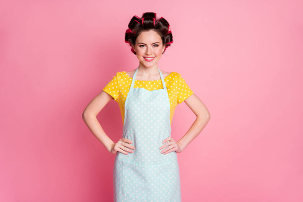 Portrait of her she nice attractive cheerful housewife wearing rollers apron hands on hips isolated over pink pastel color background - Valokuva, kuva