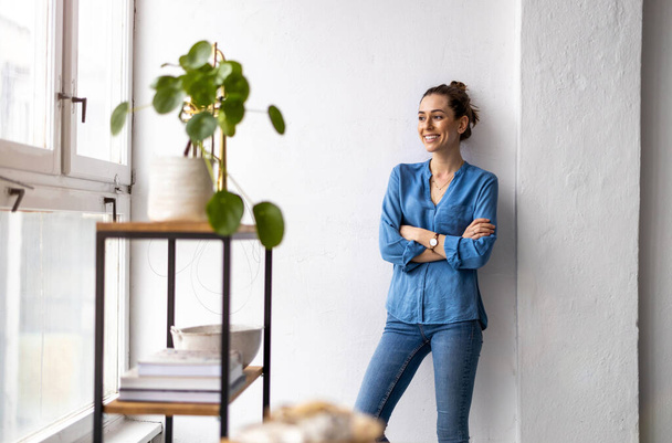 Portrait of a smiling creative woman in a modern loft space - Photo, Image