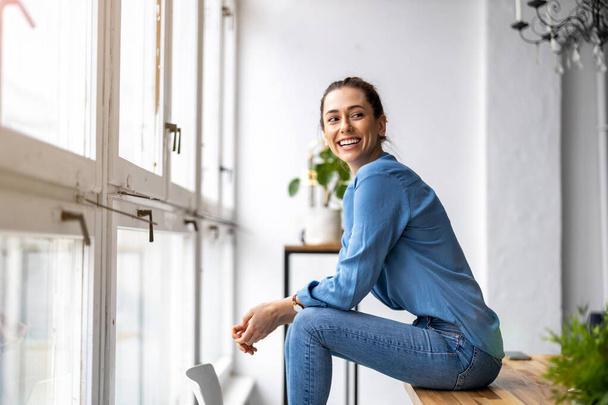 Portrait of a smiling creative woman in a modern loft space - Zdjęcie, obraz
