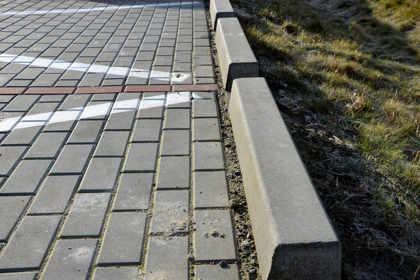 installation of concrete curbs with gaps that let water into the park into the ditch, where it seeps into the grass and does not drain into the sewer - Fotó, kép