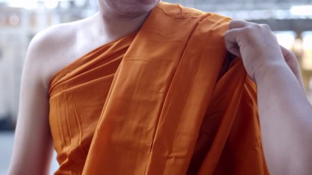 Медленное движение человека руководит новый монах в буддизме Тхеравады в Таиланде переодевается, становится покрытым особенно буддийским монашеским халатом. - Кадры, видео