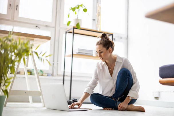 Creative young woman working on laptop in her studio - Фото, зображення