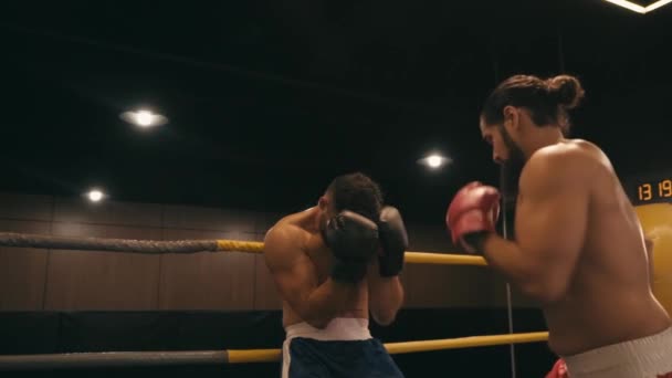 Zeitlupe eines bärtigen Boxers, der einen hispanischen Gegner im Boxring schlägt  - Filmmaterial, Video