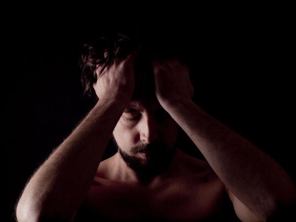 Low key image of a depressed bearded man - Fotografie, Obrázek