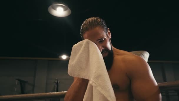 slow motion van vermoeide Spaanse bokser vegen gezicht met handdoek  - Video