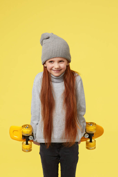 little child girl with yellow skateboard - Foto, afbeelding