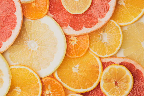 citrus fruits cut into round pieces: orange, grapefruit, lemon, tangerine. Ripe and juicy fruits, top view - Foto, imagen