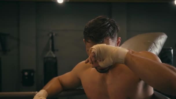 Hispanic fighter with boxing tape on hands wiping sweat - Záběry, video