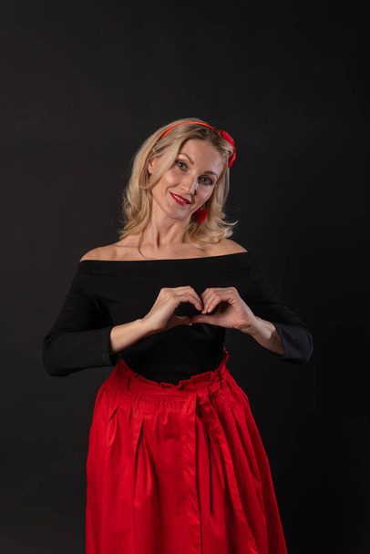 Girl hands hold the heart shape with Valentines fingers, Valentines day heart, on the floor hearts space. the formula of art. event, hearts in red dress girl, barefoot - Fotoğraf, Görsel