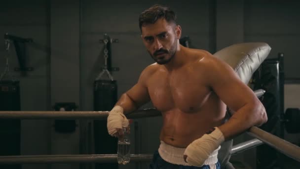 Luchador hispano con cinta de boxeo en las manos sosteniendo botella con agua - Metraje, vídeo