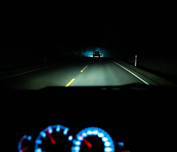 Οδηγώντας τη νύχτα σε μια σκοτεινή εθνική οδό, η προοπτική των οδηγών. Ρηχό βάθος πεδίου. Υψηλής ποιότητας φωτογραφία - Φωτογραφία, εικόνα