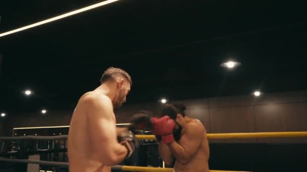 slow motion van shirtloze Spaanse en bebaarde boksers vechten op boksring  - Video