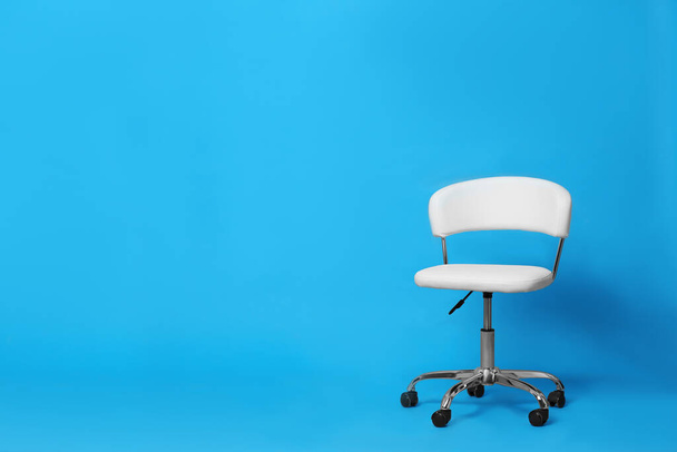 Comfortable office chair on light blue background, space for text - Фото, изображение