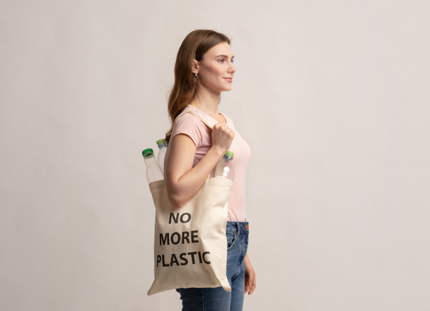 Eco activista mujer caminando con bolsa de asas con no más inscripción de plástico - Foto, Imagen