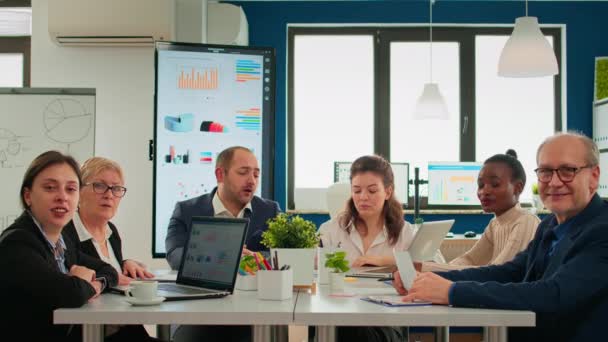 Ein bunt gemischtes Team sitzt während eines virtuellen Meetings im Konferenzraum - Filmmaterial, Video
