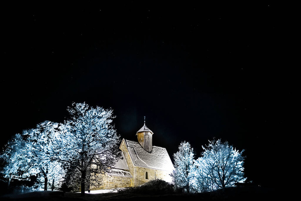 Vieille église médiévale éclairée par une nuit d'hivers étoilés. Photo de haute qualité - Photo, image