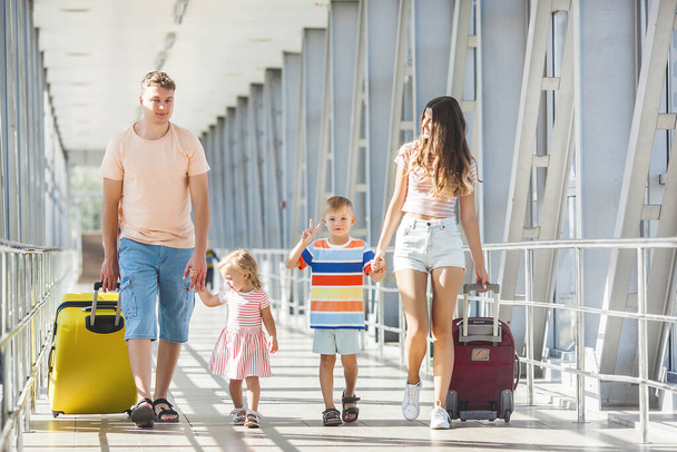 Gelukkige familie in de luchthaven vertrekt. Mensen in de terminal bereiden zich voor op de vakantie - Foto, afbeelding