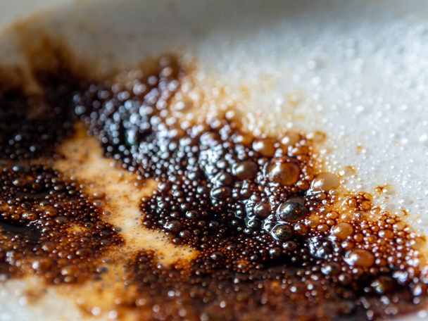 Soft white milk foam in a coffee cup And the dark brown color of the coffee powder sprinkled on it - Foto, Imagen