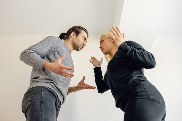 Could you just hear me? family wife and husband quarrelling, having conflict. Upset couple at home. Handsome man and beautiful young woman are having quarrel. - 写真・画像