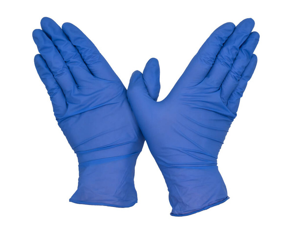 Handen met blauwe nitrilhandschoenen, duimen gekruist, vingers tegen elkaar gedrukt, handpalmen naar beneden. Vrouwelijke hand geïsoleerd, geen huid - Foto, afbeelding