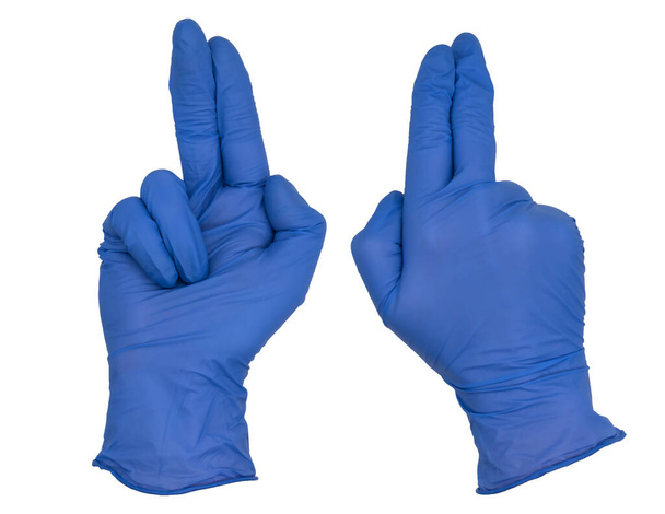 Die Hand trägt einen blauen Nitril-Untersuchungshandschuh, Zeige- und Sekundenfinger zusammen und zeigt, Ring und kleiner Finger angewinkelt. Vorder- und Rückseite - Foto, Bild