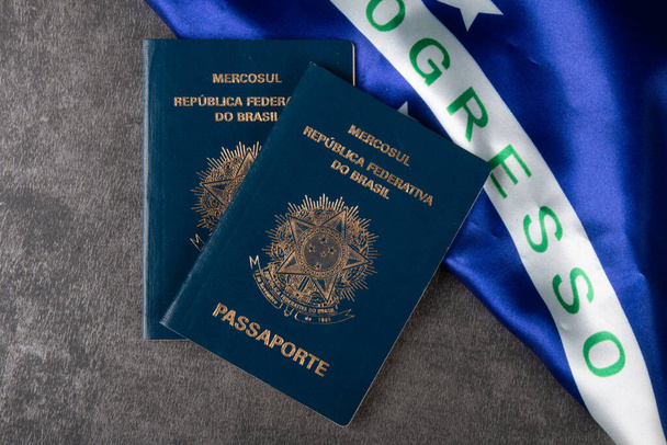 Brasilianischer Pass mit brasilianischer Flagge im Hintergrund. - Foto, Bild