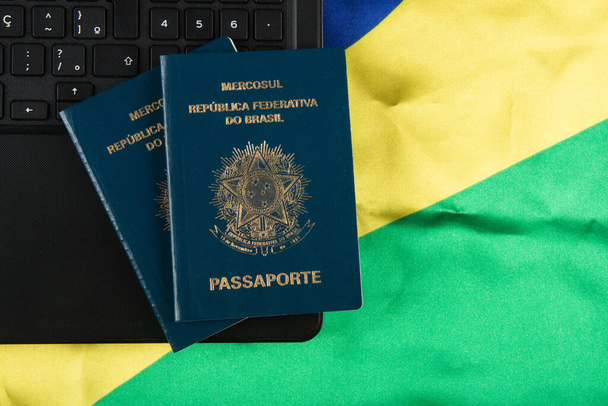 Бразильский паспорт с бразильским флагом на заднем плане. - Фото, изображение