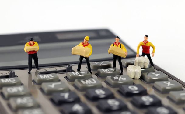 Cuatro mensajeros en miniatura de pie en una calculadora. - Foto, imagen