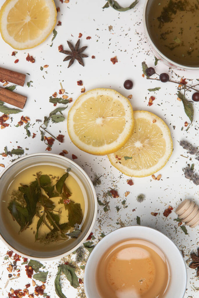 Herbal tea, top view. Dry herbs, lemon slices and tea cups on white. Herbs in bulk, zero waste and eco-friendly lifestyle, herbal medicine concept. - Photo, Image