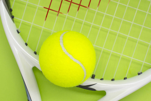 palla da tennis con racchetta su sfondo verde. Il concetto di sport. - Foto, immagini