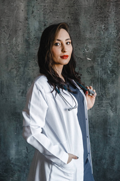 Девушка-врач в медицинском халате и со стетоскопом. - Фото, изображение