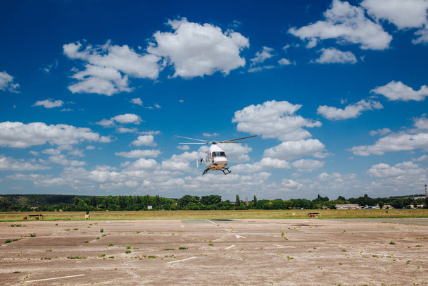 Ein weißer Hubschrauber hebt von der Landebahn ab. - Foto, Bild