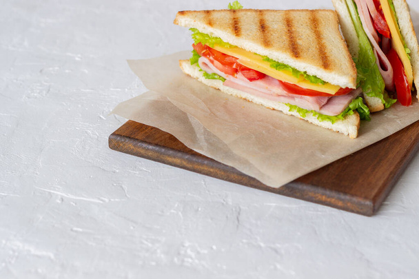 Sandwich with ham, salad, tomatoes and cheese. American cuisine. Fast food - 写真・画像