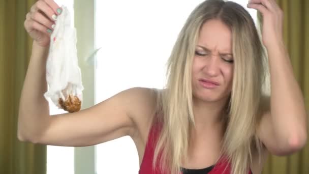 Sad woman holds dirty smelly baby diaper and grimaces at the bad smell - Footage, Video