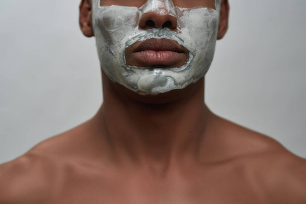 Face closeup of shirtless young african american man using facial blackhead removal mask, posing isolated over gray background - Φωτογραφία, εικόνα