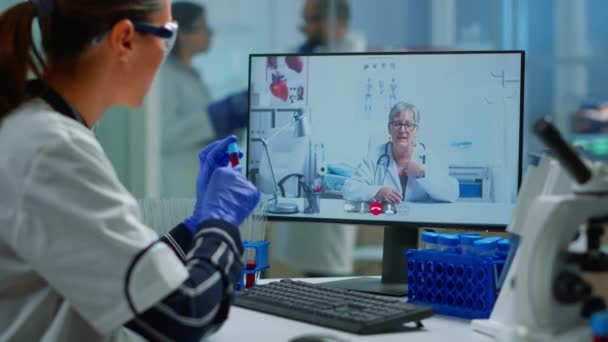 PCを使用して化学者の学生に医療オンラインアドバイスを提供する医師 - 映像、動画