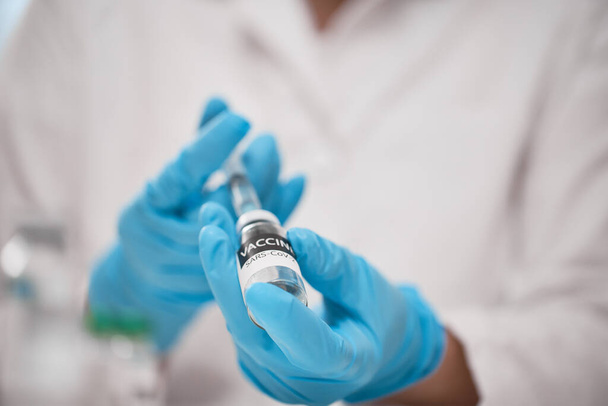 Doctor dials the vaccine into a syringe - Foto, afbeelding