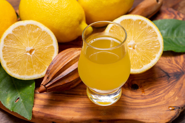 Стакан ледяного холодного сладкого лимонно-виолончельного ликера из нового урожая спелых желтых итальянских лимонов, побережье Амальфи, Италия - Фото, изображение