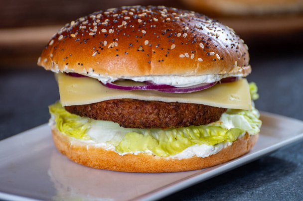 Обід або вечеря зі смачними вегетаріанськими гамбургерами, виготовленими з рослинних гамбургерів на грилі, свіжі булочки для випічки та органічні овочі крупним планом
 - Фото, зображення