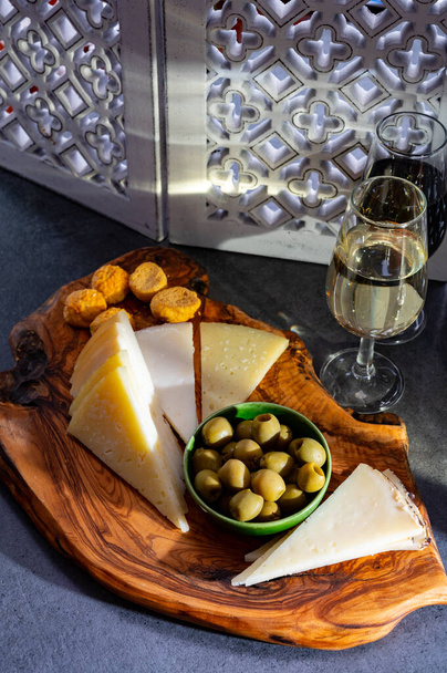 Degustación de fino seco andaluz fortificado y vino dulce de jerez con tapas tradicionales españolas, aceitunas verdes, queso manchego de cabra y oveja - Foto, Imagen