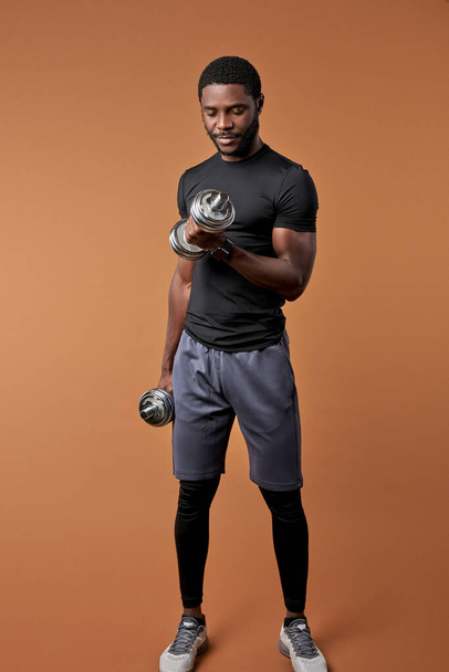 sportive fit young male raising weights, dumbbells - Fotó, kép