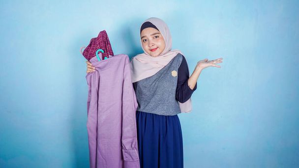 A picture of a asian muslim woman trying to pick clothes, fashion and lifestyle concept - Photo, Image