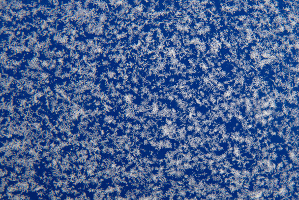 There are white snowflakes on the blue surface. Background, texture of snow. Soft focus - Fotoğraf, Görsel